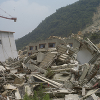地震使山坡上的巨石滾落、基岩出露，衝擊坡角的房屋，導致房屋全毀，樓梯、管線、傢俱散落一地。
