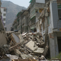 北川縣城的街道完全被兩側倒塌的房屋堵塞。由建築物的密集程度可想像以前的繁華情景，但現在已很難再度重建。