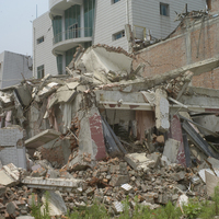 北川被震毀的建築，其中，前方較低矮建物的損壞一部分是由後方倒塌的磚牆造成。北川仍有許多建築由磚塊砌成，地震過後，倒塌的磚塊散落一地。
