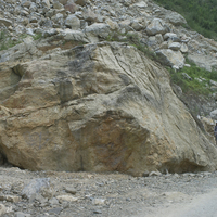 圖中巨石是從左上方的邊坡滾落下來、堆積於路邊的石頭。以石頭右方的兩位學生當比例尺，就可了解其規模之驚人！