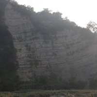 大安溪峽谷南側的岩壁類似前文提及的撓曲，都是因著斷層作用使地層產生褶皺景觀。圖中的岩層在左側呈現水平狀態，越往右側越朝上方傾斜，更右側(本圖不可見)則又突然恢復水平狀態，顯示本圖右側有斷層通過。該斷層的錯動是本區地層抬升的主因。