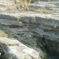 峽谷兩側呈灰白色的岩層由頁岩構成；咖啡色的岩層則由砂岩所構成。前者的硬度較小，容易受到侵蝕作用影響，在差易侵蝕作用下，形成砂岩相對突出的型態，且突出的砂岩層上常堆積從上方頁岩層崩落下來的土石，形成小尺度的崖錐景觀；圖片中央則呈現較大規模的崖錐。