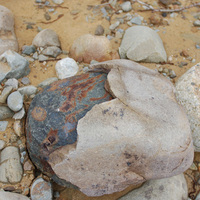 大塊的礫石因表面的裂隙及組成顆粒間孔隙，使水分得以滲入至岩石內部，進而於內部進行風化作用。當內部受風化破壞達一定程度時，造成表層岩石剝落的現象。