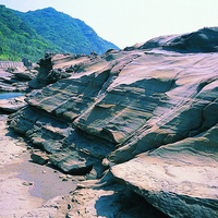 水平砂岩層理之間有明顯顏色的不同，顯示氧化作用對岩層中的鐵礦物的影響。下方有非水平層理類似荷重鑄形的沈積構造出現，代表岩層之間的岩性與沈積時的透水性有差異。