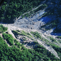大甲溪流域在921地震時所產生的崩塌至今有許多尚未恢復植被，照片中崩塌物質沿著蝕溝傾瀉而下。