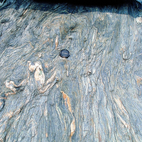 中橫公路變質岩－片岩。由於台灣的大地構造運動，在東部地區形成大規模的區域變質作用，形成許多變質岩。在照片中可以看到原本岩層中的石英脈受到變質作用的影響，成為各種小構造現象。
