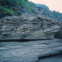 海鼻頭角是一突出的海岬。照片中的岩石內，水平與傾斜岩層交錯堆疊，形成交錯層，也代表著過去不同的沈積環境。