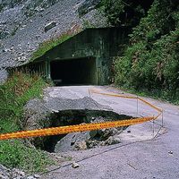 由於中橫公路谷關至德基段兩側的山壁其實並沒有很大的空間可以建築道路，所以必須以人工方式開鑿隧道或是以駁坎加填方的方式處理。照片中隧道前方道路上的大坑洞就是因下方的填方流失所造成。