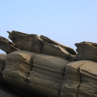 砂岩的層理分明，從底部到頂部依序可以看到波痕、岩層內氧化鐵的痕跡，有助於了解當時的沉積環境，也可以看到同樣為砂岩層，抗侵蝕的能力有所差異。從照片也可以看出岩塊受節理的影響，而顯得破碎。