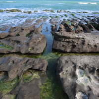 海浪沿著節理侵蝕火山礁岩，形成潮溝，照片中可見兩條垂直出現的潮溝，證明潮溝發育受節理分布影響。同時也可見大小不一壺穴等海蝕地形出現，形成一幅地景豐富的特殊景觀。