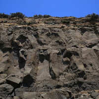 玄武岩邊坡經過降雨及含鹽分等風化、侵蝕作用的影響，邊坡上的岩塊發生崩落，原有柱狀節理的構造受風化、侵蝕後漸不明顯，呈現破碎狀。