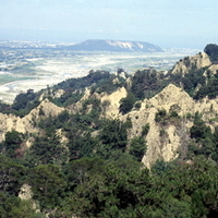 火炎山為台灣三大礫岩惡地之一，裸露的山坡和有稜有角的山脊，形成特殊自然地景。照片遠處之小平頂山丘，即為鐵鉆山。