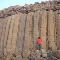 澎湖的柱狀玄武岩。可看出兩次熔岩流的痕跡，由圖中的人物可知柱狀玄武岩的大小。