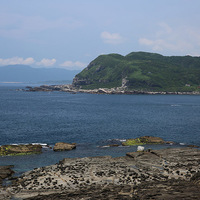 台灣東北角的海岸多為岬灣地形，照片中的海岬為龍洞岬，中間的水域為龍洞灣。龍洞岬岩石是由堅硬的四稜砂岩組成，那裏有近乎垂直的岩壁，是台灣最佳的天然攀岩場之一。