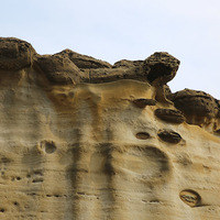 在砂岩岩層中可以看到一些凹洞，這些凹洞原本是結核的團
塊，因持續受到侵蝕最後失去支撐而掉落。岩層上仍可以看
到結核的團塊，這些將來也會持續受到侵蝕而掉落。