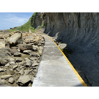 照片中右側的海崖，節理發達，此處岩石較為脆弱，經由日曬、風吹、雨打，使不少岩石脫離母岩，巨塊落石從上邊坡因節理，順著重力落下而堆在崖下，也因此有機會觀察到風化程度不同之岩石表層及深層。基部也因海浪侵蝕而形成海蝕凹壁。