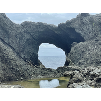 1899.
此為蘭嶼著名景點－情人洞，位於東清灣岬角，原先岩層沿著節理發育成海蝕洞，並逐漸貫穿岬角形成海蝕拱門。岩層上仍有一些節理，可見其未來演育方向，天然橋崩裂是遲早會發生的自然現象。