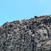 西嶼坪礫灘旁的海蝕崖，可看到柱狀玄武岩，上方的玄武岩受風化呈現破碎狀排列。