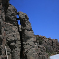 Basalt pillars will fall. In addition to the unstable foundation below, falling rocks from the rear are also one of the reasons. The crack behind the basalt column in the picture is stuck by a falling stone. As the weathering progressed, the stones propped them down along the fissures, causing the top of the stone pillars to tilt more forward, increasing the chance of falling.